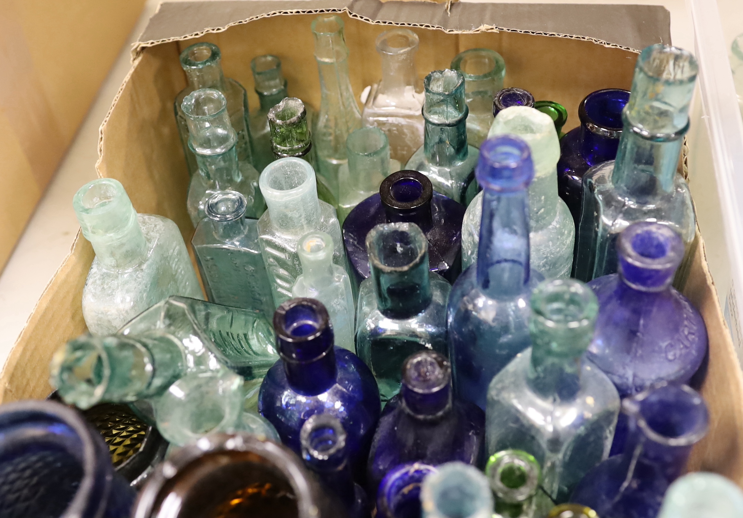 A collection of late 19th/early 20th century glass ink bottles, medicine bottles, sauce bottles and other glass vessels, brand names and advertising moulded into the glass on some examples, original paper labels to two i